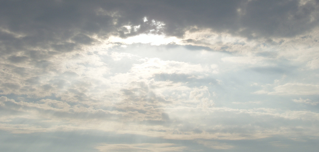 The sun breaking through late afternoon cloud cover
