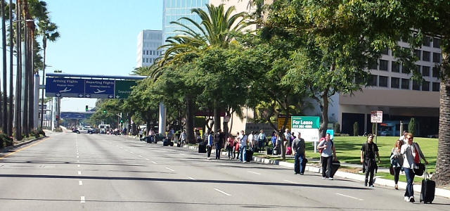 Stranded travelers leaving LAX on foot down a closed Century Blvd.