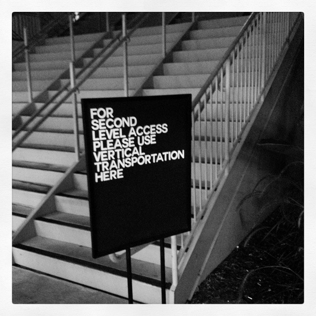 Sign in front of a staircase: For second level access, please use vertical transportation here.