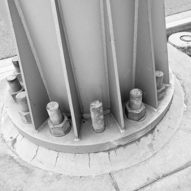 Post with large bolts, and one nut missing.