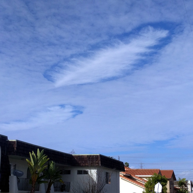 Holes in a light cloud layer, with slightly thicker clouds forming inside them.