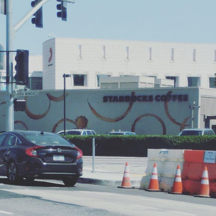 Starbucks store with brown coffee rings painted on the exterior walls.