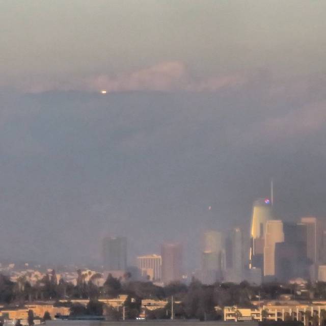 A bright light shines from the mountains above Los Angeles.