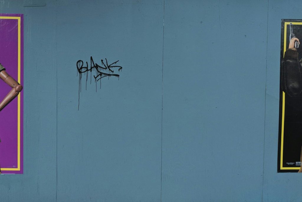 Empty space between posters where someone has scrawled the word Blank.