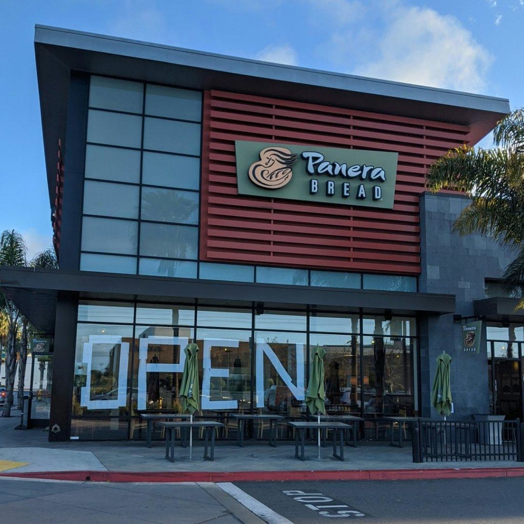 Panera restaurant with a bunch of standard sheets of paper forming the giant word OPEN.