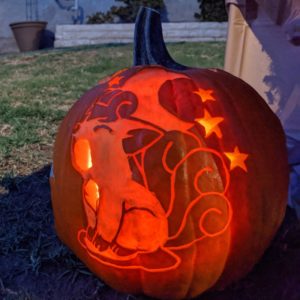 A pumpkin carved with an image of a Vulpix, a fox-like Pokemon with multiple tails that is typically orange, lit from inside.