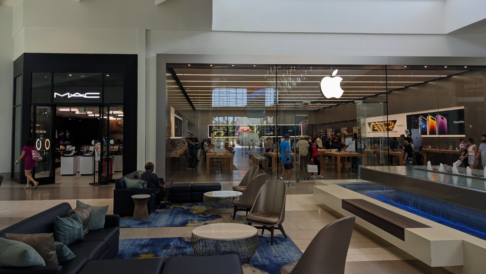Two storefronts in a mall. One is MAC Cosmetics. Right next to it is the Apple Store.