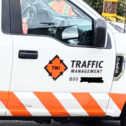 Door of a truck with orange stripes and diamond logo for 'TMI' - Traffic Management Incorporated.