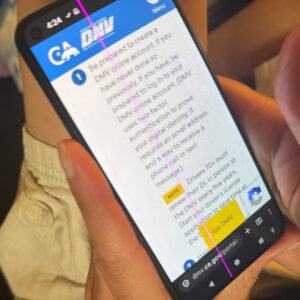 A cell phone held in a hand, showing the California DMV website. A bright magenta line is running vertically down the entire screen, including the status bar at the top and the onscreen buttons at the bottom.